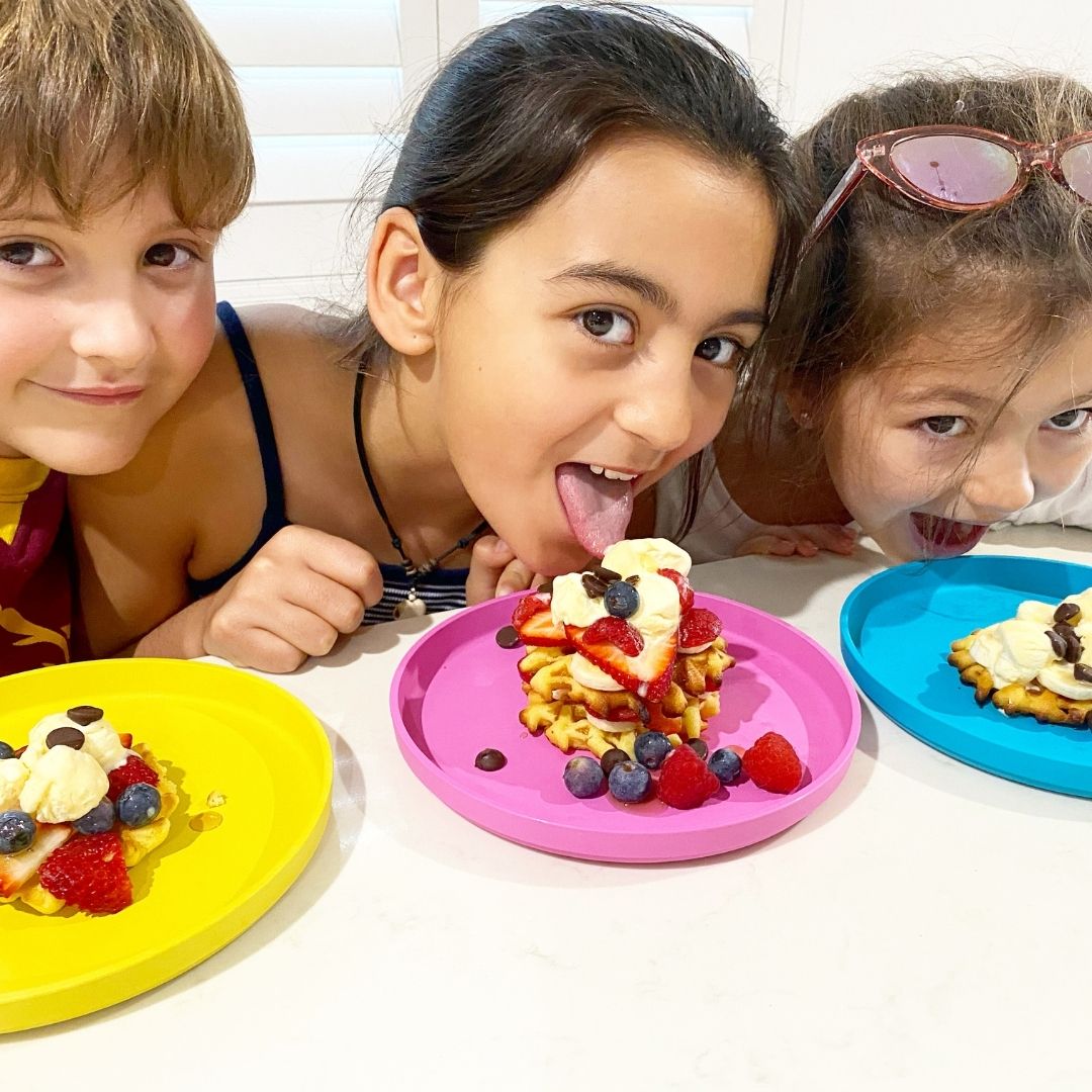 3 kids eating waffles on our bamboo plant-based plates